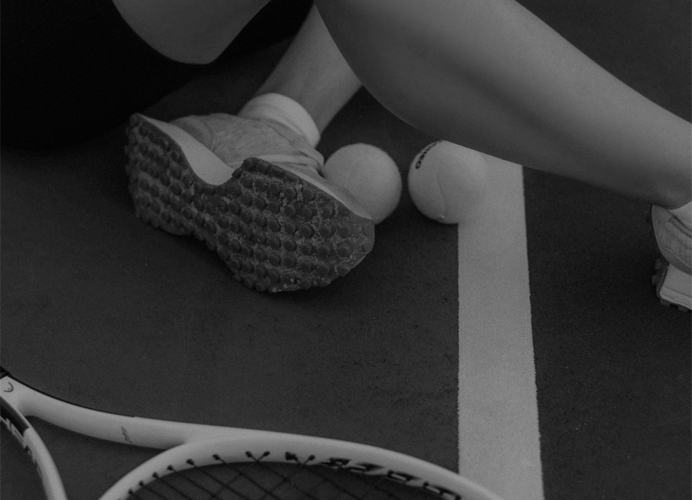 Photo en noir et blanc montrant une balle de tennis et une raquette